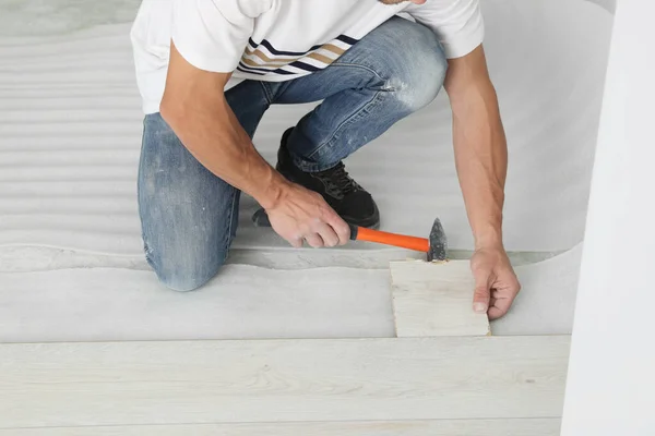 Man Using Hammer Installation New Laminate Flooring Close Seup — стоковое фото