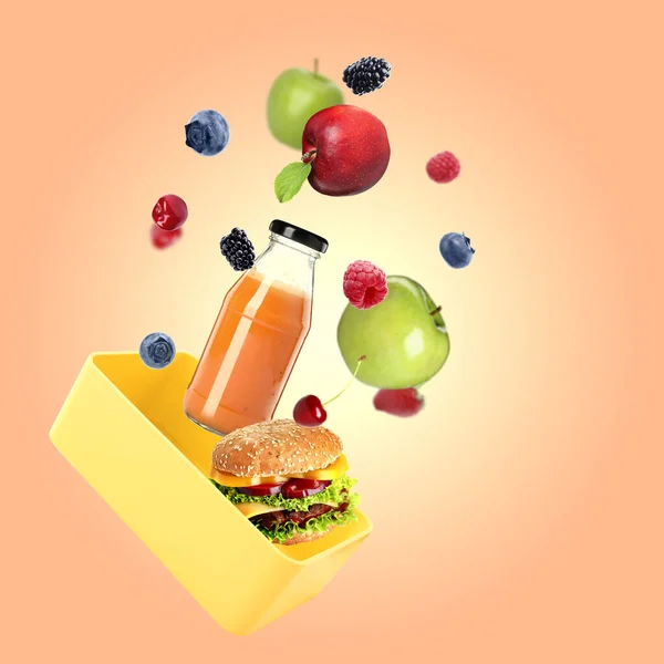 Different fresh food falling into lunch box on orange background. School meal