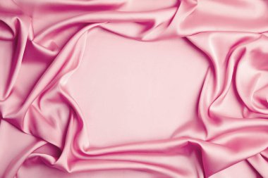 Arka plan olarak buruşuk pembe ipek kumaş, üst manzara. Metin için boşluk