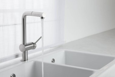 Stream of water flowing from tap in kitchen