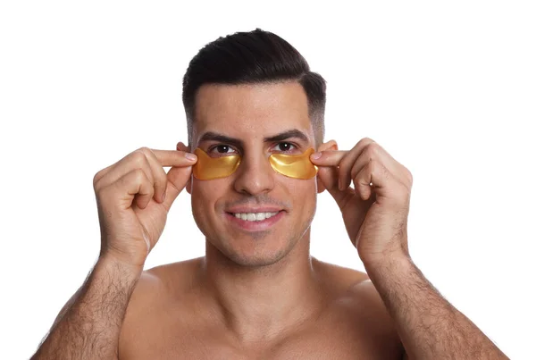 Hombre Aplicando Parches Amarillos Debajo Los Ojos Sobre Fondo Blanco — Foto de Stock