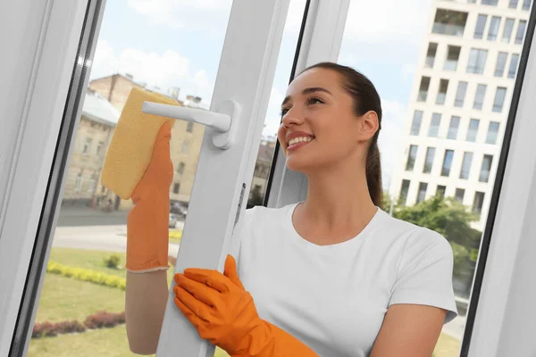 Feliz Joven Mujer Limpiando Vidrio Ventana Con Trapo Casa — Foto de Stock