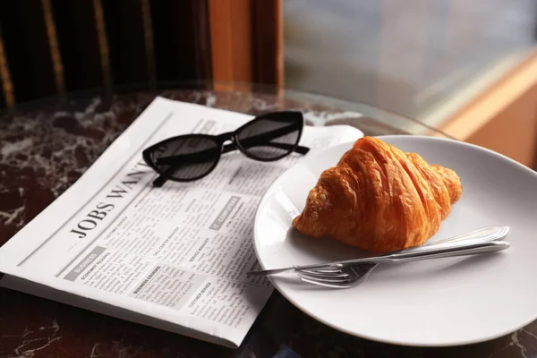 Gustoso Croissant Giornale Occhiali Sole Sul Tavolo Nero — Foto Stock