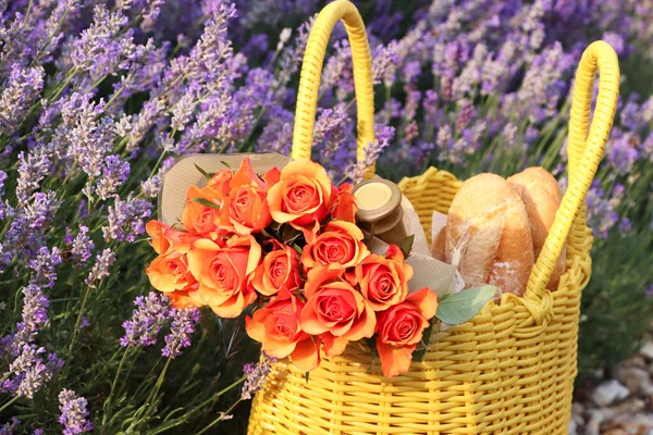 Žlutá Proutěná Taška Krásnými Růžemi Lahví Vína Bagetami Levandulovém Poli — Stock fotografie