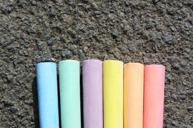 Asfaltta renkli tebeşir çubukları, düz yerde. Metin için boşluk