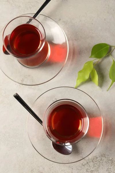 灰色のテーブルの上に伝統的なトルコ茶と緑の葉を持つ眼鏡 フラットレイ — ストック写真