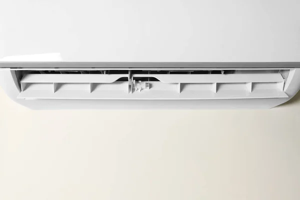 Modern air conditioner on white wall, closeup view