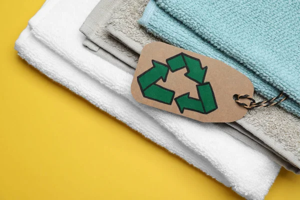 Gestapelte Handtücher Mit Recycling Etikett Auf Gelbem Hintergrund Nahaufnahme — Stockfoto