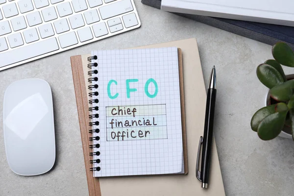 グレーのオフィステーブル フラットレイ上のCfoの略語とノートブック 財務管理 — ストック写真