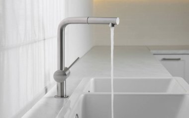 Stream of water flowing from tap in kitchen