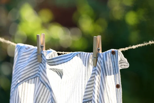 Wäscheleine Mit Trocknendem Hemd Vor Verschwommenem Hintergrund Fokus Auf Wäscheklammern — Stockfoto