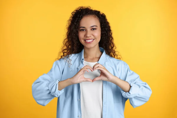 Happy Young African American Woman Making Heart Hands Yellow Background — Foto Stock