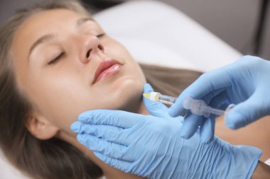 Güzeller güzeli kadın kuaförde yüz aşısı yaptırıyor.