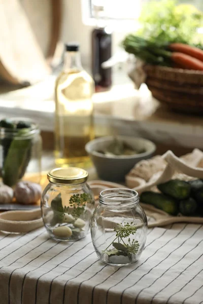 Empty glass jars and ingredients prepared for canning on table