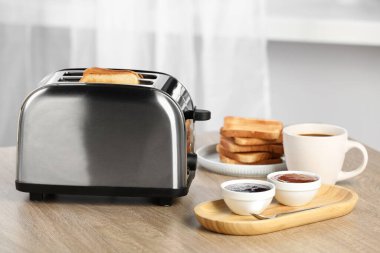 Kızarmış ekmek, kahve ve reçelli ekmek kızartma makinesi ahşap masada, mesaj için yer var. Lezzetli kahvaltı.