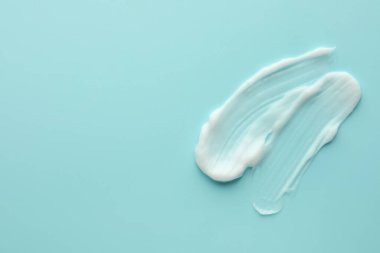 Açık mavi arka planda yüz kremi örnekleri, üst manzara. Metin için boşluk