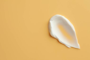 Sarı arka planda yüz kremi örneği, üst manzara. Metin için boşluk