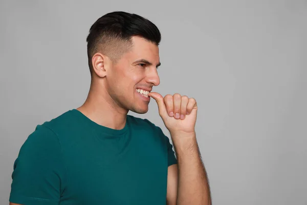 Hombre Mordiéndose Las Uñas Sobre Fondo Gris Mal Hábito — Foto de Stock