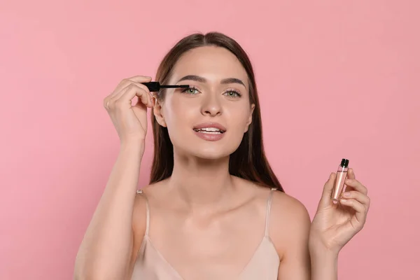 Young Woman Applying Oil Her Eyelashes Pink Background — Stock Photo, Image