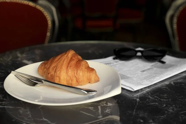 Leckeres Croissant Zeitung Und Sonnenbrille Auf Schwarzem Tisch — Stockfoto