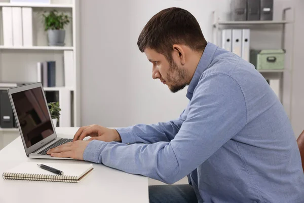 一个体态不好的人在办公室的笔记本电脑上工作 脊柱侧弯的症状 — 图库照片