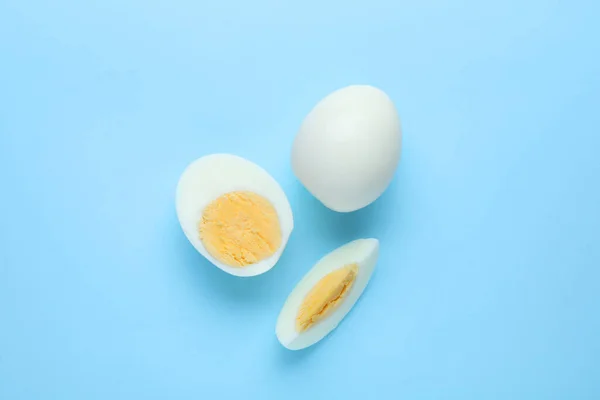 Fresh hard boiled eggs on light blue background, flat lay