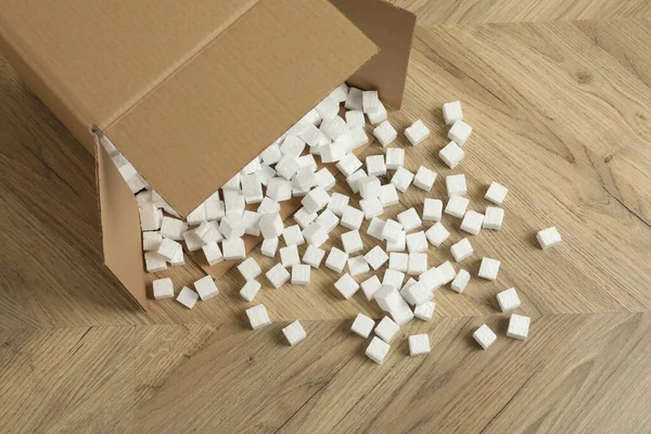 Caixa Papelão Virada Com Cubos Isopor Chão Madeira Vista Acima — Fotografia de Stock