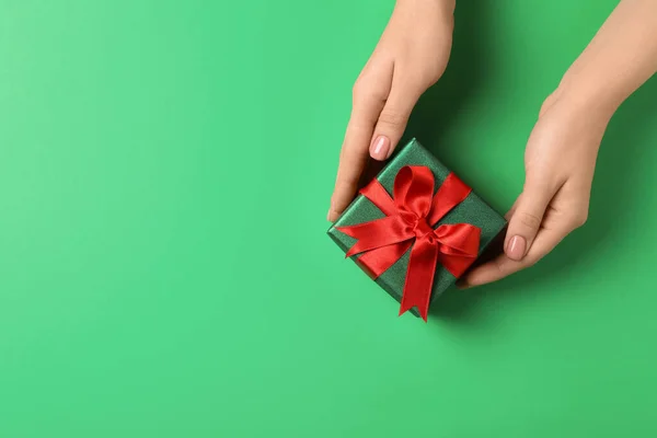 緑の背景に美しく包まれたクリスマスのギフトボックスを持つ女性は トップビュー テキストのスペース — ストック写真