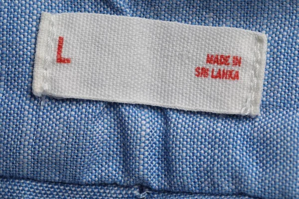 Clothing label on light blue garment, top view