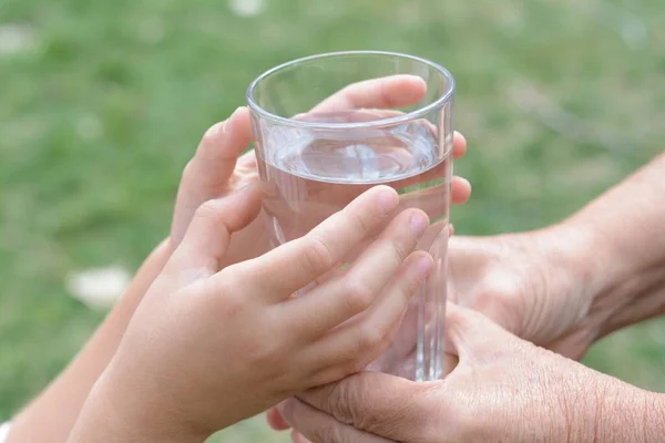 Criança Dando Copo Água Para Mulher Idosa Livre Close — Fotografia de Stock