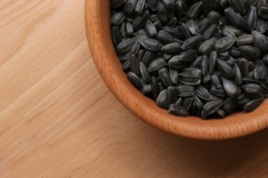 Tahta masadaki kasede organik ayçiçeği tohumları, üst manzara. Metin için boşluk