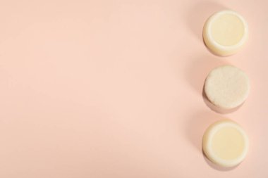 Pembe arka planda sağlam şampuan kalıpları, düz yatış. Metin için boşluk