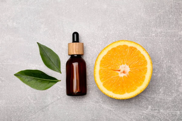 Botella Aceite Esencial Con Rebanada Naranja Hojas Sobre Mesa Gris — Foto de Stock