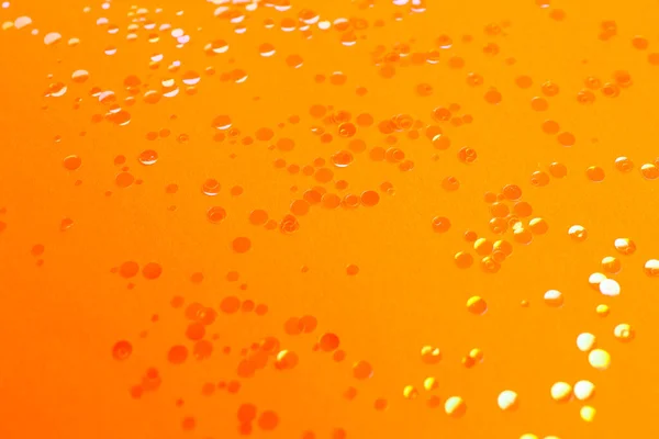 オレンジの背景に散在する光沢のある明るい輝き — ストック写真