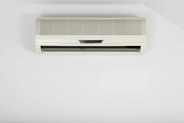 Modern air conditioner on white wall indoors