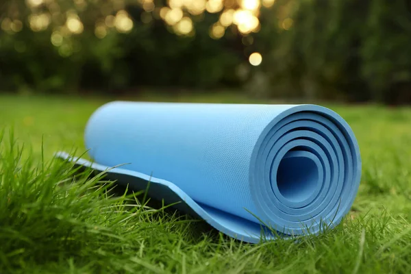 户外新鲜绿草上明亮的壁毯或健身垫 — 图库照片