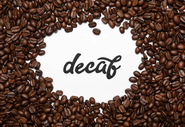 Woord Decaf Koffiebonen Witte Achtergrond Bovenaanzicht — Stockfoto