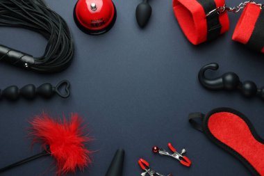 Düz kompozisyon ve farklı seks oyuncakları koyu mavi arka planda, metin için boşluk