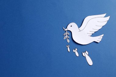 Beyaz güvercin zeytin dalı ve mavi arka planda bombalar. Metin için boşluk