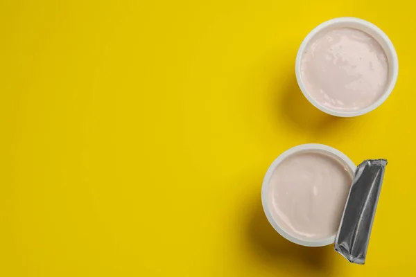 Bicchieri Plastica Con Gustoso Yogurt Sfondo Giallo Posa Piatta Spazio — Foto Stock