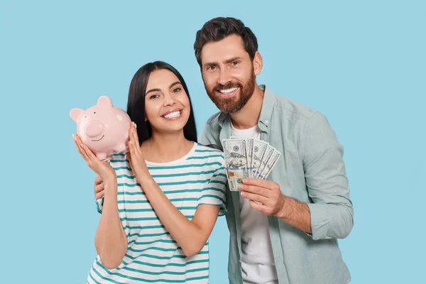 Pareja Feliz Con Dinero Alcancía Cerámica Sobre Fondo Azul Claro — Foto de Stock