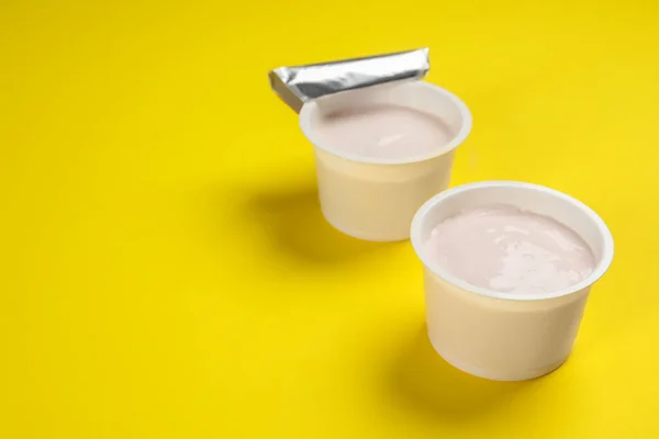 Plastové Poháry Chutným Jogurtem Žlutém Pozadí Prostor Pro Text — Stock fotografie
