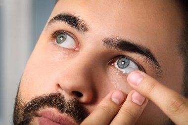 Kontak lens takan genç adamın yakın görüntüsü
