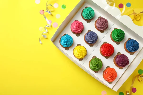 Caixa Com Diferentes Cupcakes Confetes Fundo Amarelo Flat Lay Espaço — Fotografia de Stock