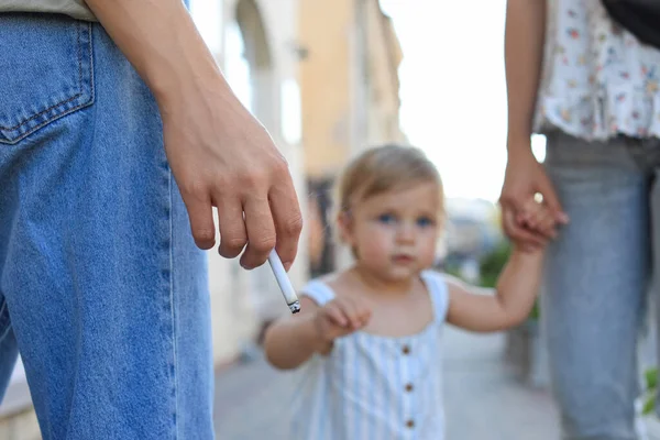 屋外の公共の場所で女性の喫煙タバコ 閉じます 子供の近くでタバコを吸ってはいけない — ストック写真