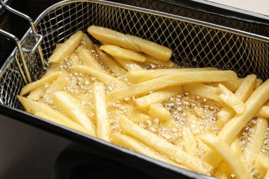 Lezzetli patates kızartması pişiriyorum, sıcak yağda, yakından.