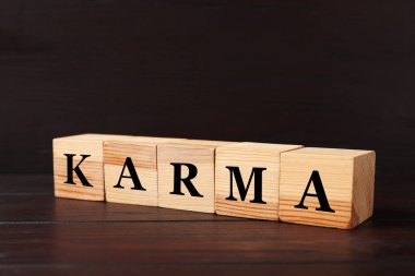 Word Karma made of cubes with letters on black wooden background clipart