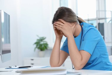 Hastanedeki işyerinde yorgun bir doktor, mesaj atmak için yeri var.