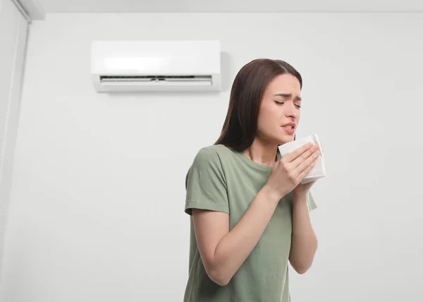 Femme Souffrant Froid Dans Chambre Avec Climatiseur Sur Mur Blanc — Photo