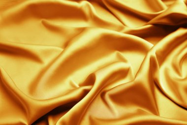 Arkaplan olarak narin altın ipek kumaş, yakın plan görünüm